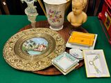 a green table with a gold plate and other items on it