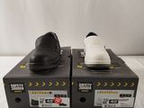 une paire de chaussures noires et blanches posée sur des cartons