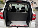 l'arrière d'une voiture blanche dont le coffre est ouvert, sur un parking