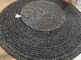 un tapis rond noir et blanc posé sur un parquet dans un salon