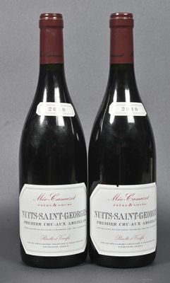 two bottles of red wine sitting next to each other on a table