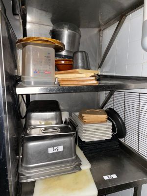 a metal shelf with pots and pans on top of it