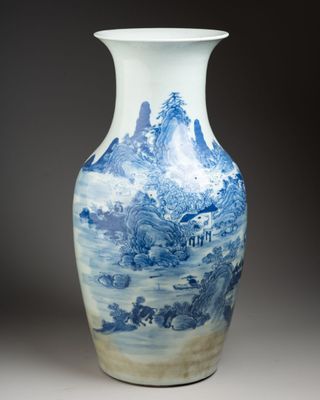 a blue and white vase with a mountain scene on it