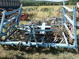 a blue plow that is sitting in the grass