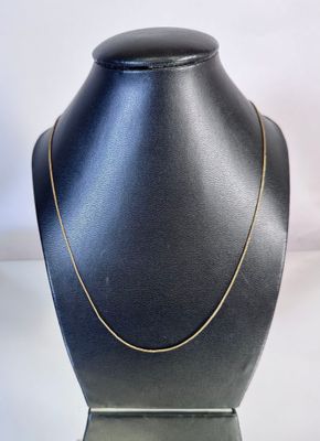 a black mannequin with a gold chain on it