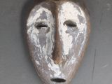 un masque accroché au mur d'un immeuble
