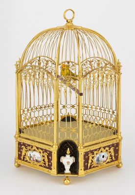 une cage à oiseaux en or avec un oiseau à l'intérieur