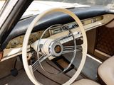 dashboard of a classic car with a wooden steering wheel and tan leather seats