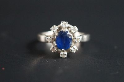 une photo d'une bague sertie d'un saphir bleu et de diamants, posée sur une table
