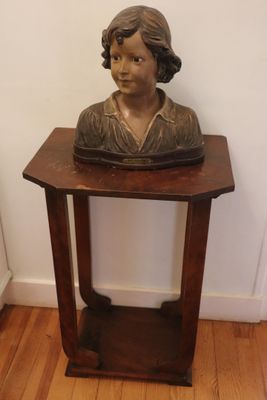 a small wooden table with a statue of a woman on it