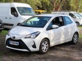 a white toyota yaris parked in a parking lot
