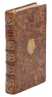 un vieux livre orné d'un emblème doré sur la couverture