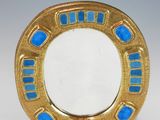 a close up of a gold plate with blue glass in it