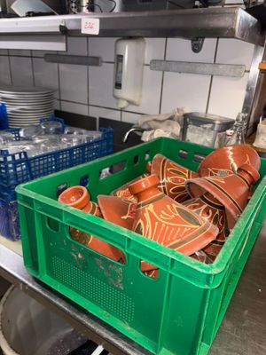 a green crate filled with plates and bowls in a kitchen