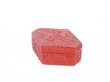 une petite boîte rouge posée sur une surface blanche