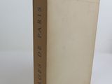 an old book sitting on top of a white table next to a white wall