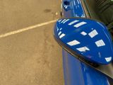 a blue car parked in a parking lot next to a parking meter