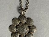 a close up of a necklace with a bunch of coins on it
