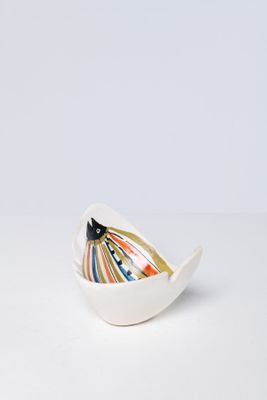 small white bowl with colorful stripes on it on a white surface