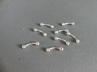 six paires de piercings de nez en argent sur un fond gris