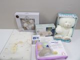 a white teddy bear sitting on a table next to other items