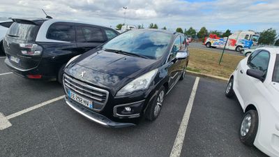 Des voitures sont garées sur un parking, avec un ciel nuageux en arrière-plan.