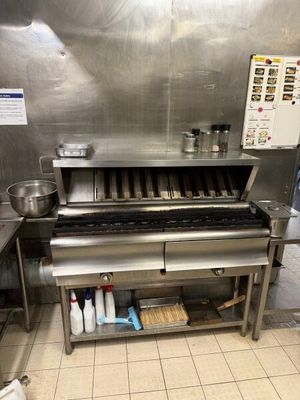 une cuisine équipée d'une cuisinière et d'un plan de travail sur lequel sont posés des casseroles et des poêles