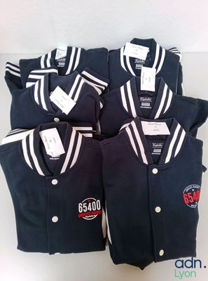 four men ' s baseball uniforms are laid out on a table