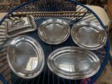 six silver trays on a blue wire table