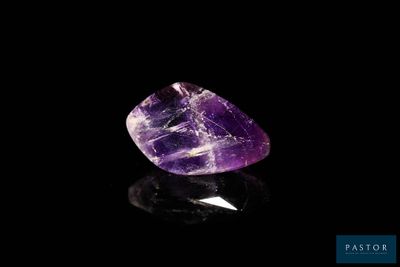 a purple amethorate stone on a black surface