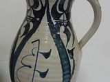 a blue and white vase sitting on a table next to a green vase