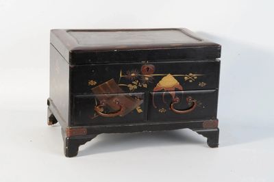 une petite boîte noire décorée de fleurs et d'oiseaux