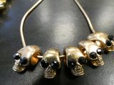 gold skull necklace with black stones on a black table