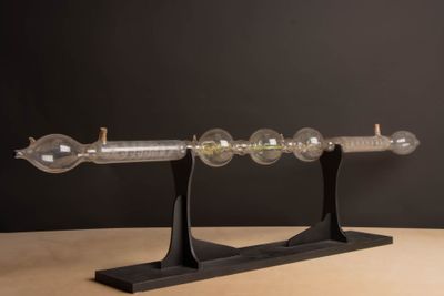 une image représentant un objet en verre posé sur un socle en bois