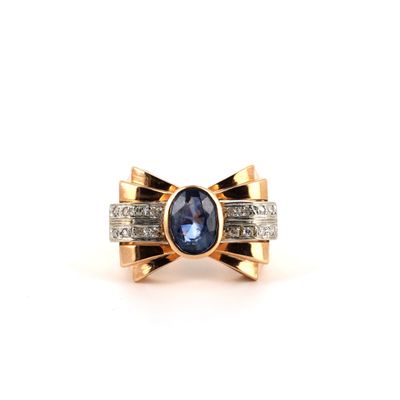 gros plan d'une bague avec une pierre bleue et des diamants