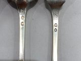 three spoons and a fork sitting on a table