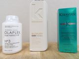 two bottles of hair products on a table next to a box of hair products