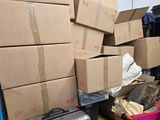 a pile of boxes sitting on the floor next to a suitcase