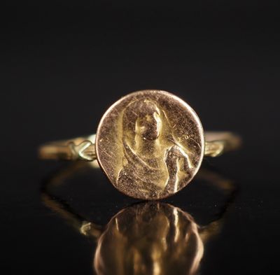 gros plan d'une pièce d'or sur laquelle figure une femme
