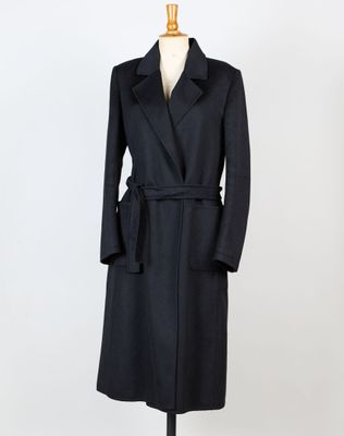 un manteau noir sur un mannequin sur fond blanc