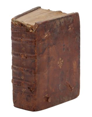 un vieux livre est posé sur une surface blanche