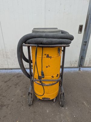 a yellow dust collector with a hose attached to it