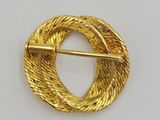 an image of a gold broochle with a circular design