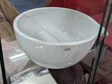 un bol blanc posé sur une étagère en verre dans un magasin