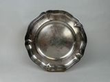 an antique silver plate on a white table with a white background
