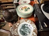 a man that is looking at some plates on a table