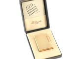 a small gold cigarette case in a box on a white surface