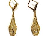 pair of gold tone earrings with black and white stones on them