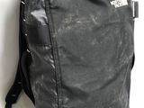 un sac à dos noir posé contre un mur