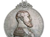une image représentant une médaille d'argent sur laquelle figure le portrait d'un homme